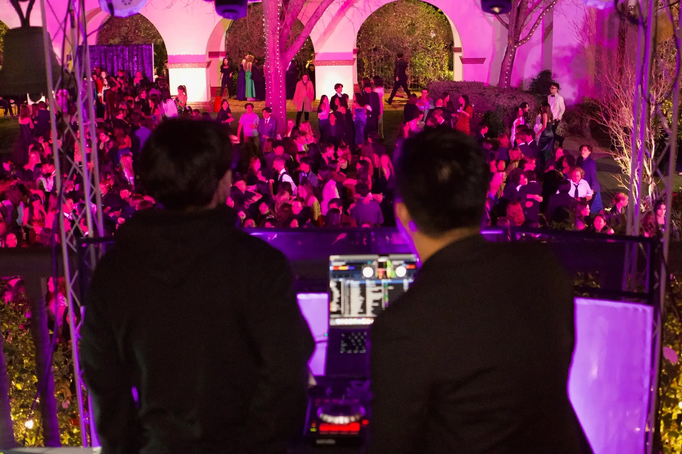 Community Mixers DJs behind the decks at a packed school dance